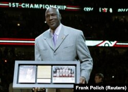Michael Jordan recibe una placa conmemorativa, en marzo de 2011, por el 20 aniversario del primer campeonato de la NBA ganado por los Chicago Bulls. (Archivo REUTERS/Frank Polich)