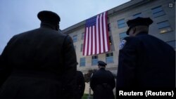 Los socorristas saludan mientras se despliega una bandera estadounidense en el Pentágono al amanecer para conmemorar el ataque terrorista de 2001 contra el Pentágono, durante una ceremonia de celebración el 11 de septiembre de 2023.