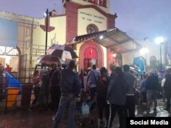 Cubanos frente al Santuario Nacional de San Lázaro, en El Rincón, bajo la persistente llovizna. (Facebook/Canal Habana)
