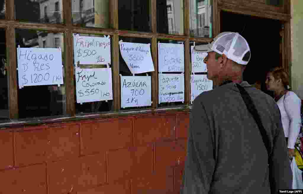 Cubanos miran los precios de los alimentos en un negocio privado en La Habana, el 20 de diciembre de 2023.
