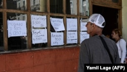 Cubanos miran los precios de los alimentos en un negocio privado en La Habana, el 20 de diciembre de 2023. (Yamil Lage/AFP).