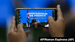 Un periodista toma una fotografía con un teléfono celular del ministro de Relaciones Exteriores cubano, Bruno Rodríguez, dando una conferencia de prensa en La Habana, Cuba. En la isla el Estado controla todos los medios de comunicación y persigue el periodismo independiente.