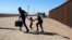 Una familia de migrantes cubanos se apresura a cruzar la frontera en Yuma, Arizona, en mayo de 2021. (Ringo Chiu/ AFP)