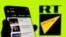 La app de RT en un teléfono móvil delante de los logos de RT y Sputnik. REUTERS/Dado Ruvic/Ilustración