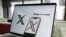 La página de inicio de la compañía tecnológica X en una laptop y un celular.