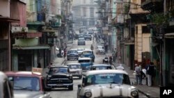 Autos clásicos americanos utilizados como taxis colectivos circulan por una calle de La Habana. (AP/Desmond Boylan/Archivo)