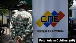 Un miembro de la milicia venezolana hace guardia cerca de un punto de registro y actualización de datos de votantes, en Caracas en 2024. 