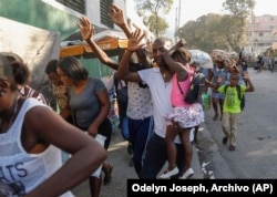 Vecinos huyen de sus casas durante los enfrentamientos entre la policía y miembros de una pandilla en el barrio de Portail en Puerto Príncipe, Haití, el jueves 29 de febrero de 2024.