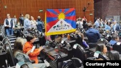 Salvador Caro Cabrera, miembro de la Cámara de Diputados de México, muestra una bandera nacional tibetana durante una visita al Congreso mexicano del nuevo embajador de China en México, el 26 de abril de 2023. (Foto: Radio Asia Libre).