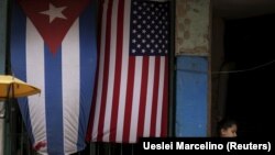 Una niña frente a una casa adornada con banderas de Estados Unidos y Cuba en las afueras de La Habana, Cuba, 21 de marzo de 2016 (REUTERS/Ueslei Marcelino)