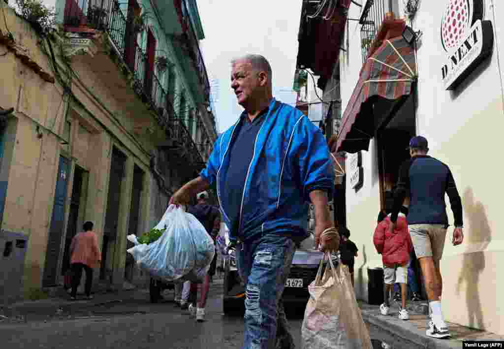 Un hombre carga verduras por una calle de La Habana, el 20 de diciembre de 2023.