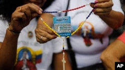 Partidarios de la oposición sostienen rosario con un volante del candidato presidencial Edmundo González durante evento de oración en Caracas, Venezuela, 07/214. . (AP Foto/Cristian Hernandez)