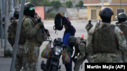 Soldados registran a un hombre en un control de seguridad antes de la segunda vuelta de las elecciones presidenciales en Durán, Ecuador, el viernes 13 de octubre de 2023. (AP Foto/Martín Mejía)