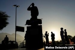 Militares venezolanos alrededor de una estatua del difunto presidente Hugo Chávez, en Caracas, durante las conmemoraciones del décimo aniversario de su muerte. (AP Photo/Matias Delacroix)