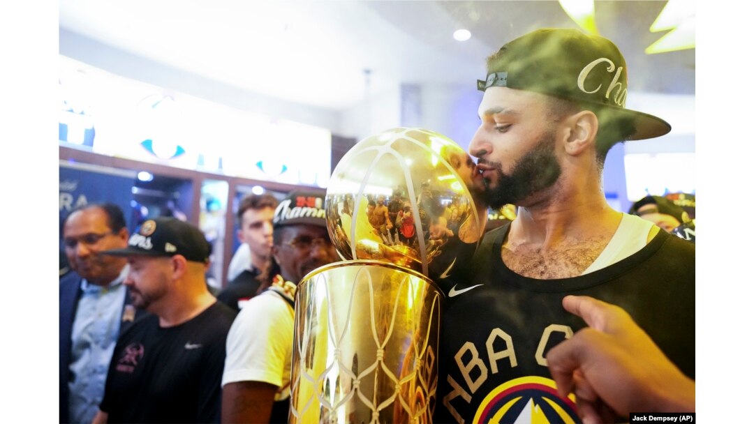 Jamal Murray, de los Denver Nuggets, besa el trofeo del campeonato de la NBA dentro del vestuario, después del triunfo del equipo sobre el Miami Heat. (AP/Jack Dempsey)