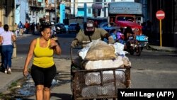 Un hombre empuja una carretilla con sacos de alimentos por una calle de La Habana. (Yamil Lage/AFP)