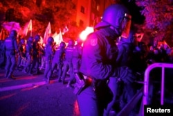 La policía antidisturbios española se enfrenta a manifestantes durante una protesta cerca de la sede del Partido Socialista de España (PSOE), el 6 de noviembre de 2023. REUTERS/ Juan Medina