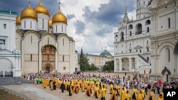 Sacerdotes ortodoxos y fieles asisten a una ceremonia en el Kremlin con la Catedral de la Asunción al fondo, en Moscú, el 28 de julio de 2024. (Igor Palkin/Servicio de Prensa de la Iglesia Ortodoxa Rusa vía AP)