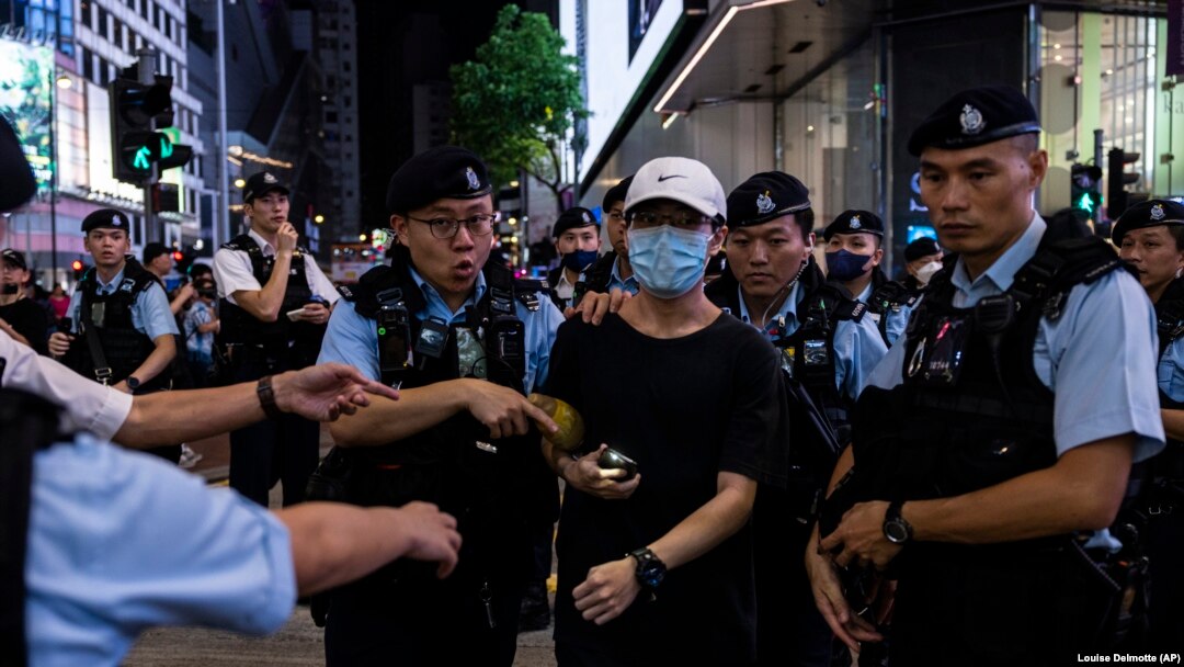 La policía detiene a una mujer en el Parque Victoria, en Hong Kong, en el aniversario 34 de la masacre de Tiananmén. (AP/Louise Delmotte).