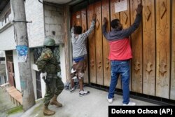 Dos personas contra una puerta con las manos en alto y un militar procede a registrarlos mientras patrullan por el sur de Quito, Ecuador, el viernes 12 de enero. ( AP/Dolores Ochoa)