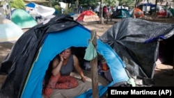 Una migrante en una tienda de campaña espera su permiso de tránsito para atravesar Honduras hacía Guatemala en su ruta a EEUU, en octubre de 2023. (AP/Elmer Martinez)