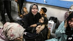 Palestinos heridos por un ataque contra el hospital Ahli Arab sentados en el piso del hospital Al Shifa, en Gaza, Franja de Gaza, el martes 17 de octubre de 2023. (AP Foto/Abed Khaled)