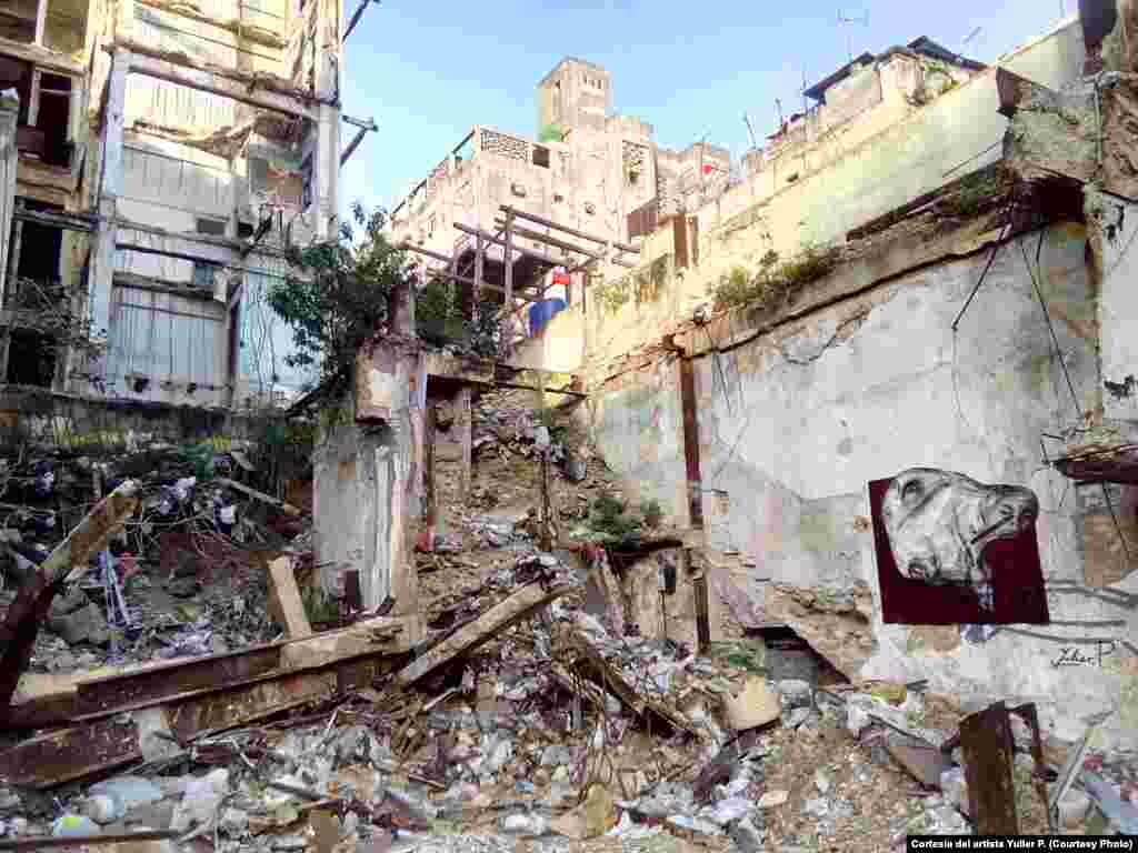 Obra del artista cubano Yulier P. El grafitero aprovecha las ruinas de los derrumbes, para insertar sus piezas en el espacio urbano.