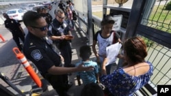 Oficiales de Aduanas y Protección Fronteriza de EE. UU. revisan los documentos de migrantes en el Puente Internacional 1 en Nuevo Laredo, México. (AP/Marco Ugarte/Archivo)