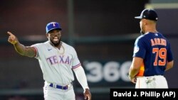 Adolis García, de los Rangers de Texas (izq.), habla con José Abreu (79) de los Astros de Houston, antes de un partido de béisbol este domingo, 16 de abril de 2023, en Houston. (AP/David J. Phillip)