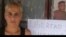 Esposa de Duniesky Ruiz, junto al cartel que pide la liberación del preso del 11J.