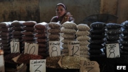 Una mujer vende frijoles en un mercado.