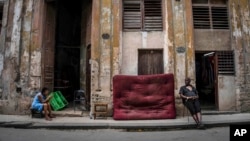 Mujeres sentadas en la acera de una calle, en La Habana, Cuba, el sábado 9 de julio de 2022. (Foto AP/Ramon Espinosa)