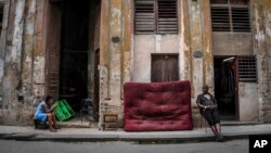 Mujeres sentadas en la acera de una calle, en La Habana, Cuba, el sábado 9 de julio de 2022. (Foto AP/Ramon Espinosa)