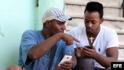  Dos personas navegan por la internet en un dispositivo móvil hoy, viernes 3 de julio del 2015, en una de las zonas habilitadas con Wifi en La Habana (Cuba).