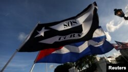 Exiliados ondean banderas cubanas frente al restaurante Versailles de Miami en solidaridad con las protestas en la isla. (REUTERS/Marco Bello)