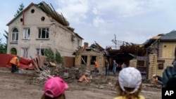 Niños observan a trabajadores que remueven los escombros tras un ataque con cohete a una vivienda en Kramatorsk, región de Donetsk, este de Ucrania.Niños observan a trabajadores que remueven los escombros tras un ataque con cohete a una vivienda en Kramat