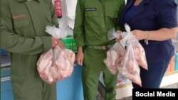 Una empleada de una TRD de Mayabeque entrega paquetes de pollo a dos bomberos de esa provincia que participaron en la extinción del incendio en la base de supertanqueros de Matanzas. (Foto: Facebook)