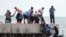 Residentes de la zona ayudan a balseros cubanos cerca de Key West, Florida, el 22 de agosto de 2022. (AP Photo/Mary Martin).