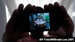 El 21 de junio de 2022 en North Miami Beach, un migrante cubano que pidió no ser identificado muestra una foto del bote rudimentario que él mismo fabricó para salir de Cuba junto a tres amigos.