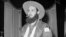 El comandante Rolando Cubela se fuma un puro al entrar al Palacio Presidencial, en La Habana, el 4 de enero de 1959. (AP/Archivo)