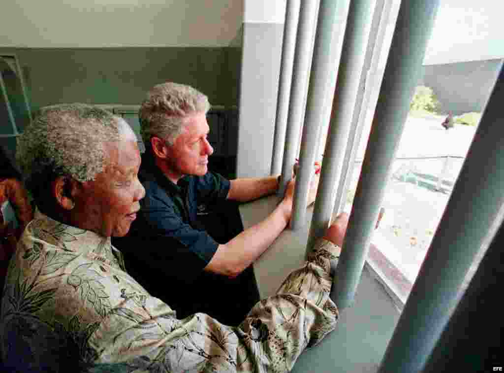 Nelson Mandela (i) (Madiba) junto al expresidente estadounidense Bill Clinton (d), en una celda en la cárcel en donde Mandela pasó 18 de sus 27 años como prisionero político en Robben Island (Sudáfrica). 