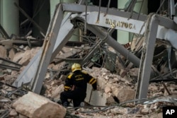 Un rescatista busca sobrevivientes en el lugar de una explosión mortal que dañó el hotel Saratoga, en La Habana, el viernes 6 de mayo de 2022. (AP Foto/Ramón Espinosa)