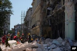 Los trabajadores de emergencia caminan entre los escombros frente al Hotel Saratoga de cinco estrellas después de una explosión mortal en La Habana Vieja, Cuba, el viernes 6 de mayo de 2022. (AP Foto/Ramón Espinosa)
