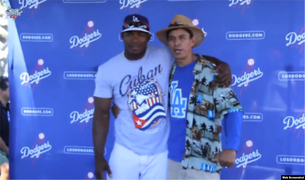El jardinero cubano Yasiel Puig abraza a un admirador en el Día de la Herencia cubana en el Dodgers Stadium.