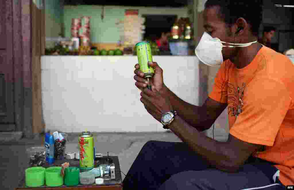 Archivo 2014.- Un trabajador por cuenta propia rellena fosforeras por una calle de La Habana (Cuba). 