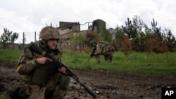 Soldados ucranianos patrullan el domingo 15 de mayo de 2022 en una población al norte de Járkiv, en el este de Ucrania. (AP Foto/Mstyslav Chernov)