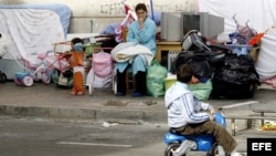  Una mujer aguarda junto a sus hijos tras el desalojo de un bloque de viviendas 