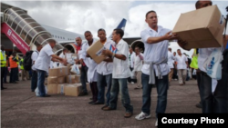 Miembros de la brigada médica cubana enviada a Liberia descargan materiales a su llegada a Monrovia.