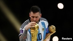 Lionel Messi, de Argentina, besa el trofeo de la Copa del Mundo después de recibir el premio Balón de Oro tras ganar el mundial 2022. (REUTERS/Kai Pfaffenbach/File Photo).