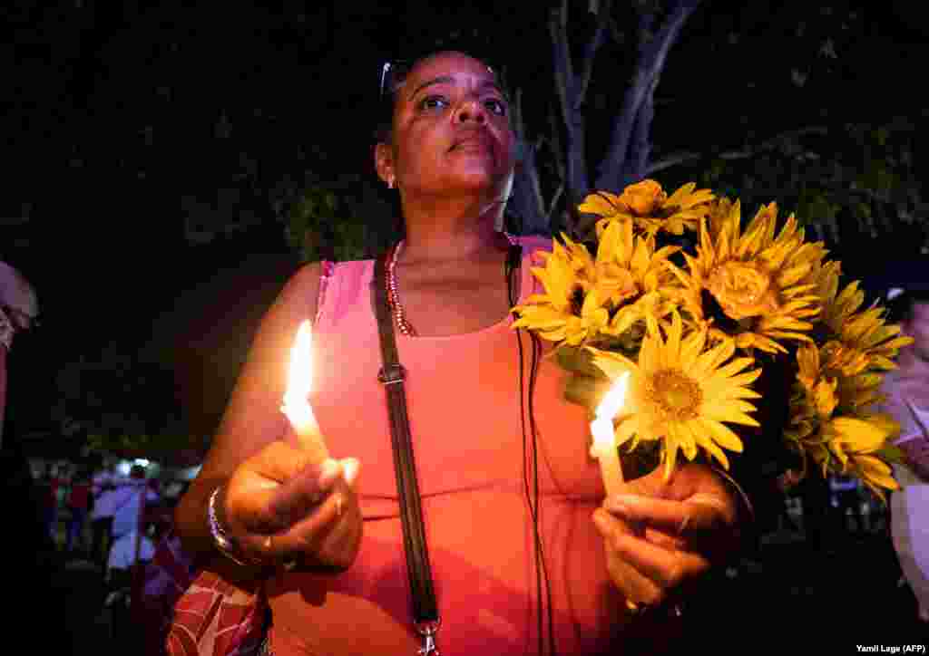 Una mujer venera a San Lázaro, a quien ofrece flores y velas, frente al Santuario Nacional dedicado al santo en El Rincón. (Yamil Lage/AFP)